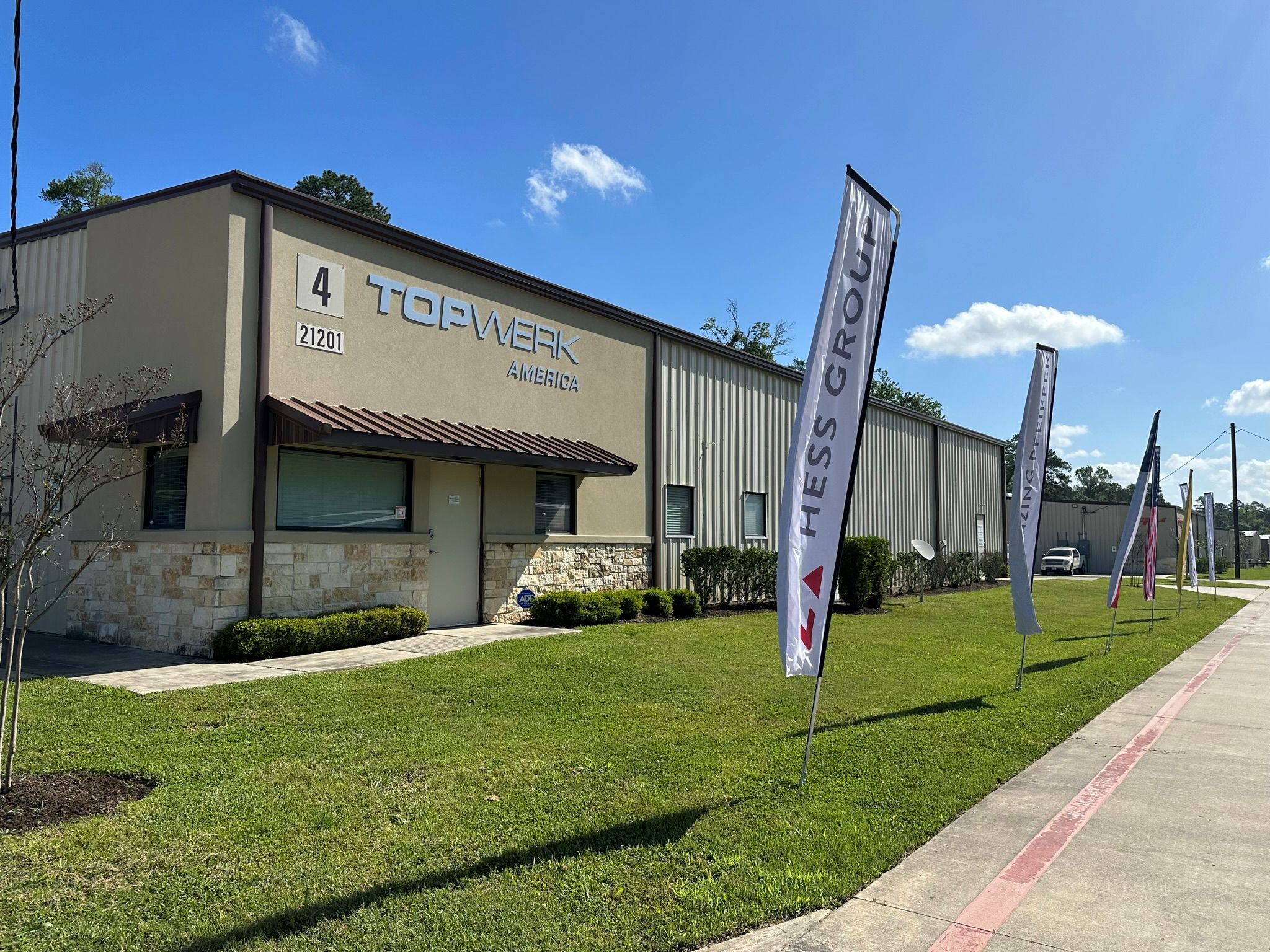 TOPWERK America building with TOPWERK signage and partner flags outside.