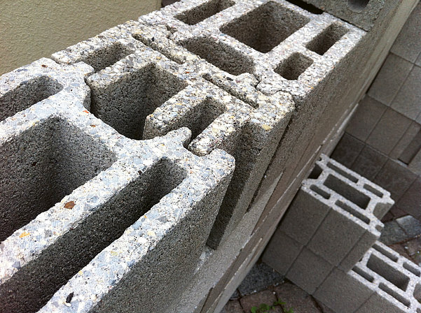 Close-up of calibrated concrete blocks with precise edges and contact surfaces for accurate wall construction.