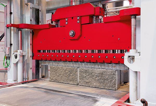 SR SCHINDLER splitting machine processing concrete blocks to create consistent split-face textures.
